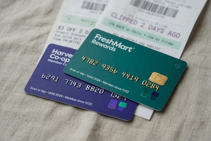 Smartphone showing stacked digital coupons and loyalty rewards at grocery store checkout