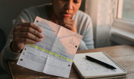 Person reviewing budget and savings plan at desk with calculator and notepad