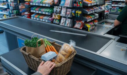 Person comparing grocery prices and receipts at home while planning meal budget