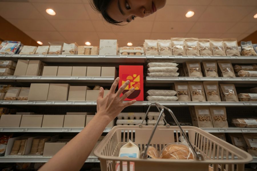 Shopper looking at cereal aisle with full cart, illustrating impulse buying triggers