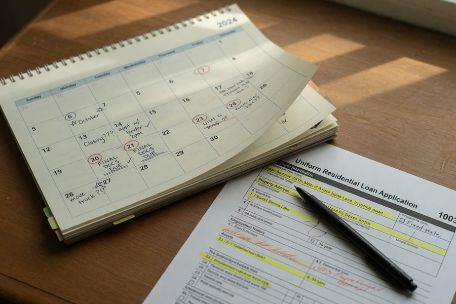 Underwriter reviewing a thick mortgage file with highlighted compensating factors