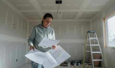 Homeowner reviewing renovation plans and loan documents at kitchen table