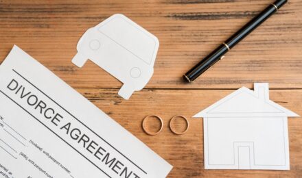 Person reviewing mortgage documents and credit report after divorce settlement