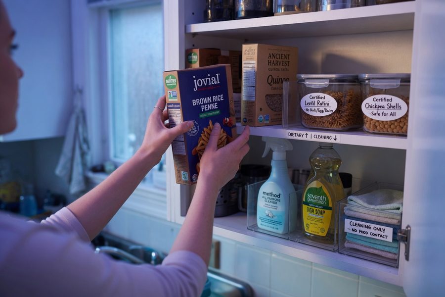 Organized pantry shelves showing gluten-free labeled items, canned goods, and dried legumes neatly arranged