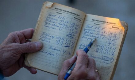 Retiree reviewing monthly budget and household expenses on a table