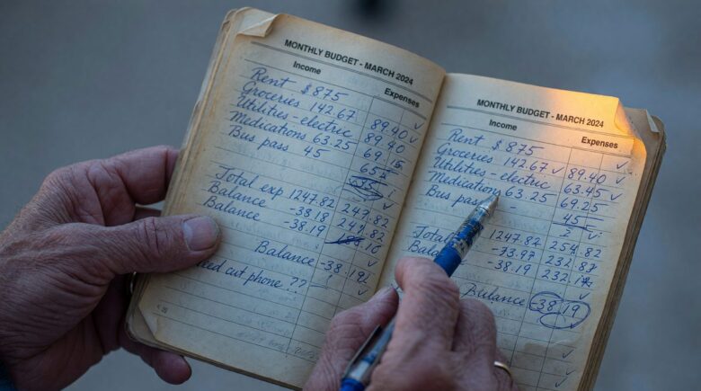 Retiree reviewing monthly budget and household expenses on a table