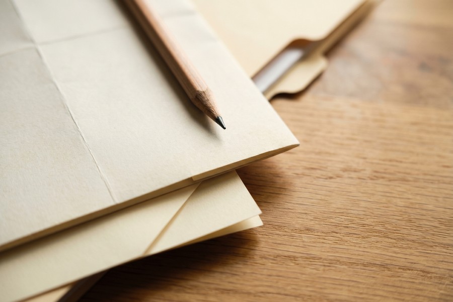 Freelancer reviewing business expense receipts and mileage log at a home desk