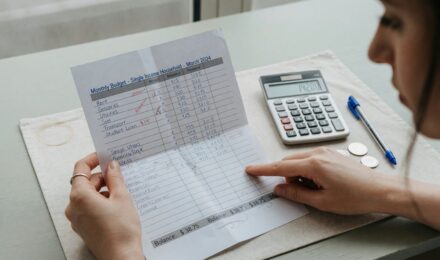 Family budgeting together at kitchen table with laptop and documents