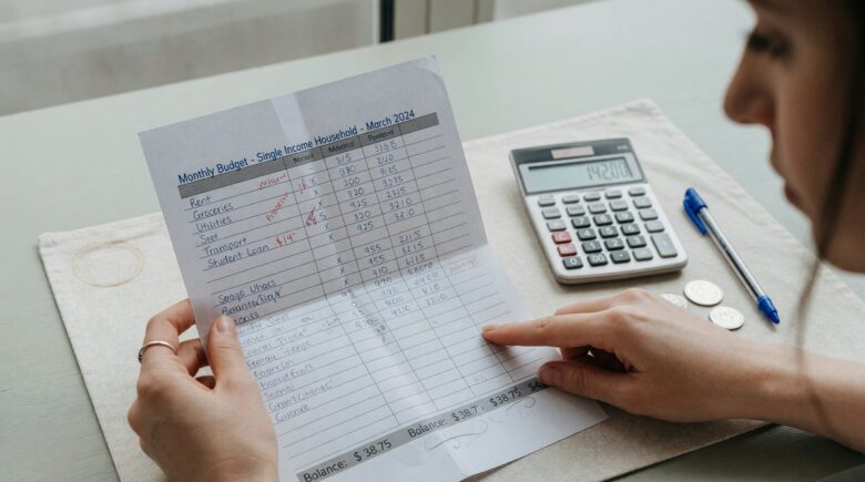 Family budgeting together at kitchen table with laptop and documents