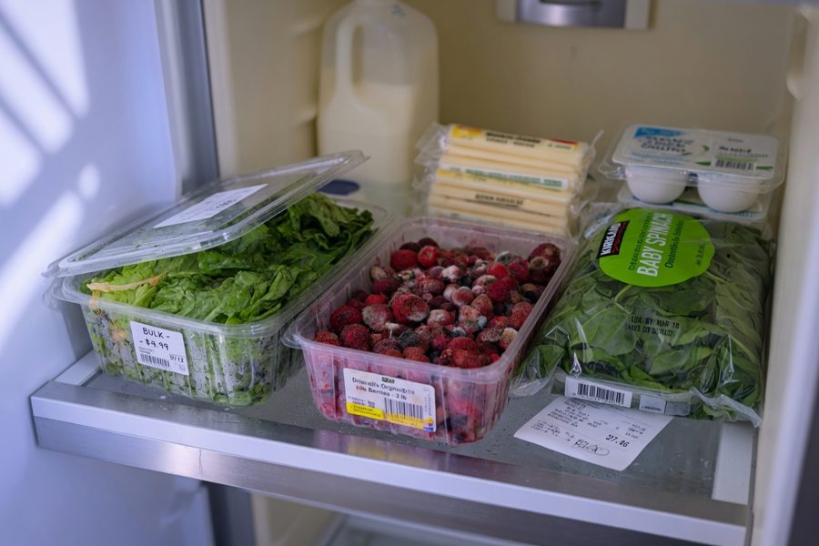 Mother and child grocery shopping together, comparing prices in store aisle