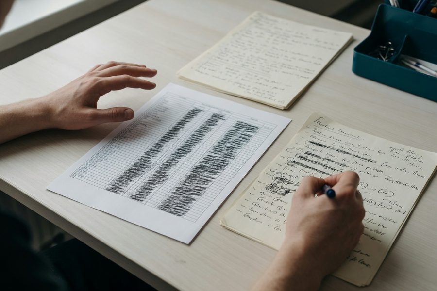 Split-screen comparison of a phone showing automated banking transfers and a handwritten budget notebook