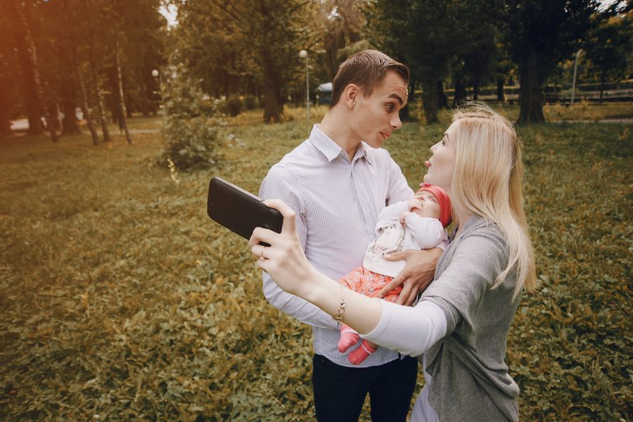 Couple comparing insurance quotes on laptop with kids nearby
