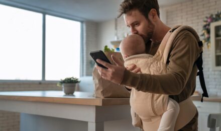 Parents reviewing baby budget expenses on a laptop with infant nearby