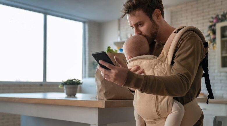 Parents reviewing baby budget expenses on a laptop with infant nearby