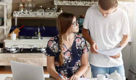 First-time homebuyer reviewing mortgage documents and financial paperwork at a desk