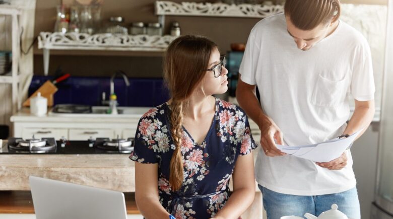 First-time homebuyer reviewing mortgage documents and financial paperwork at a desk
