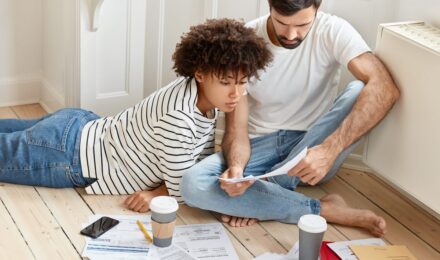 Illustration showing tax forms and calculator next to a house, representing first-time homebuyer tax credits in 2026