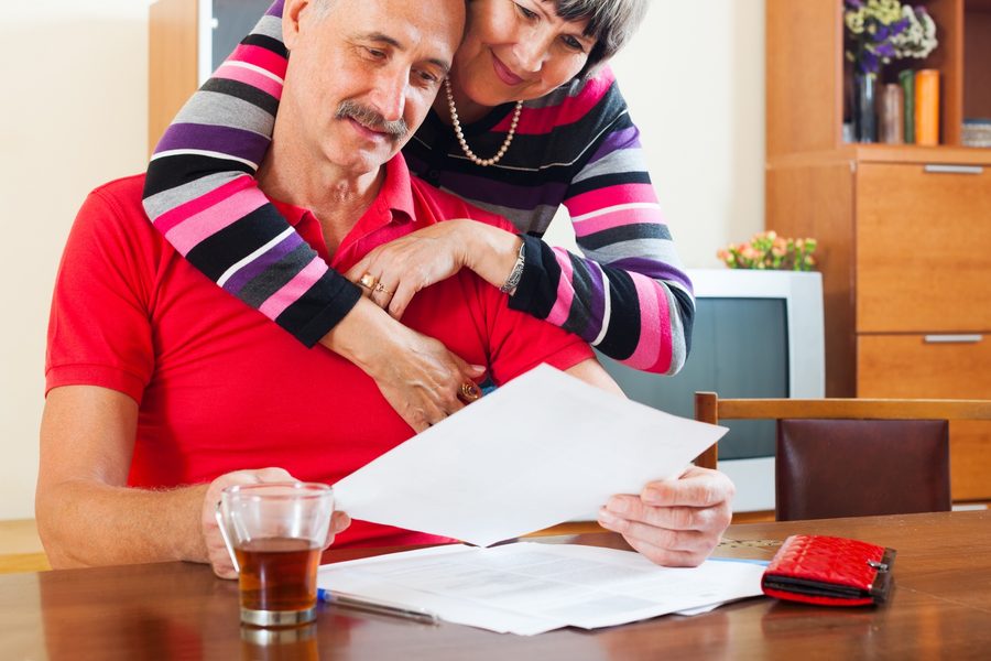 Stack of mortgage application documents with SSA-1099 forms on top