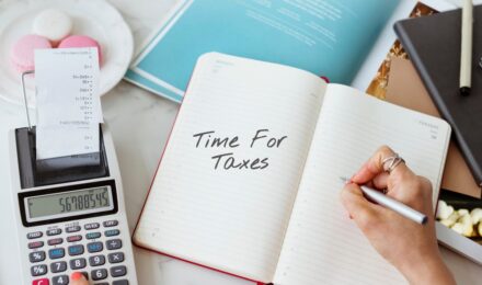 A person reviewing a 1099-NEC form and calculating tax payment