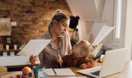Single mom at laptop reviewing investment portfolio and monthly budget on $48,000 salary