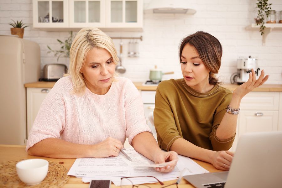 Woman sitting at laptop smiling with zero balance credit card statement