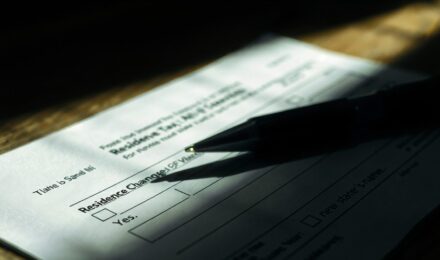 Person organizing tax documents and moving boxes for state relocation